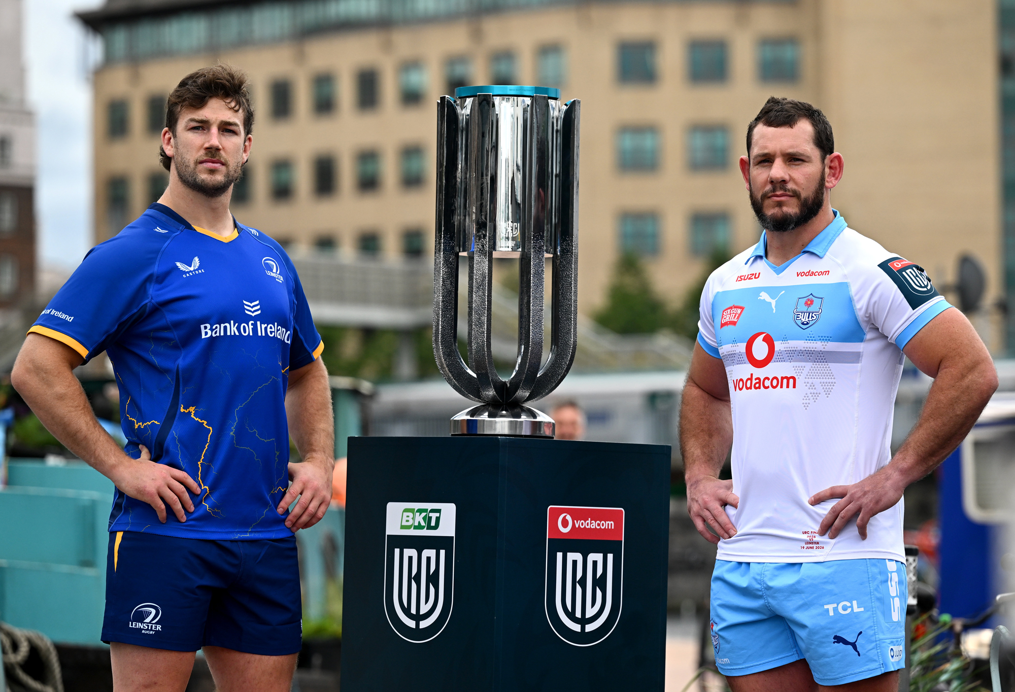 Leinster and Bulls captains Caelan Doris and Marcell Coetzee standing either side of the URC trophy at Grand Canal Dock in Dublin